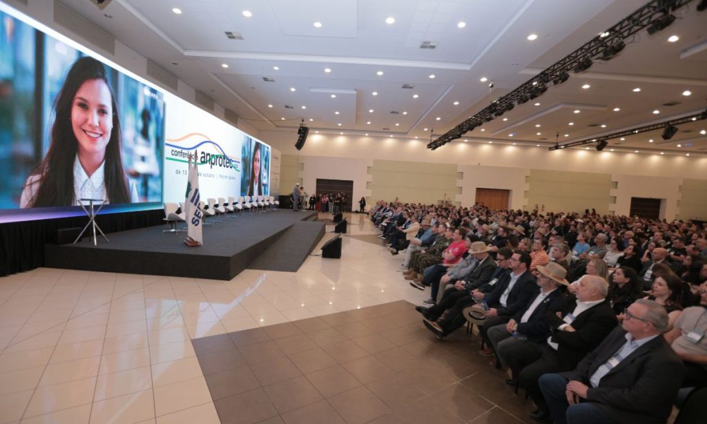 Telão e parte da plateia no evento de abertura da Conferência Anprotec 2025