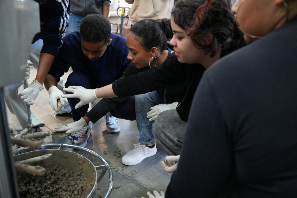 Alunos moldando concreto feito com auxílio da nanotecnologia na Jornada Científica.