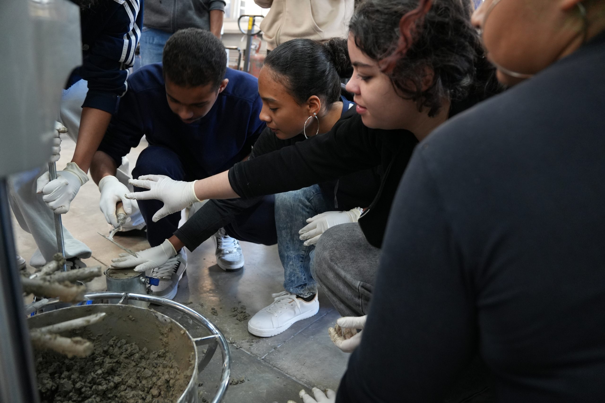 Alunos moldando concreto feito com auxílio da nanotecnologia na Jornada Científica.